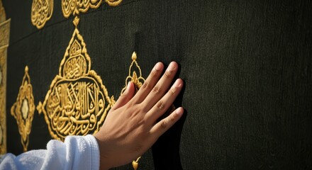 Close-Up of a Hand Touching the Kaaba Covering with Intricate Gold Embroidery, Symbolizing Faith and Spiritual Connection in Islamic Rituals