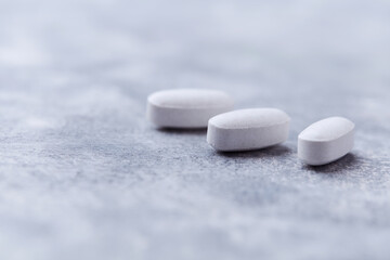 Amino acids tablets on wooden background. Soft focus. Close up
