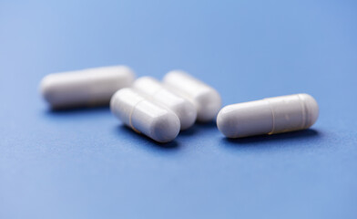 Arginine capsules on bright background. Soft focus. Close up. Copy space.	