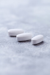 Amino acids tablets on wooden background. Soft focus. Close up