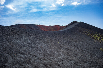 Stunning view of one of the craters of Mount Etna, Catania, Sicily, Italy, with the gray and reddish lava slopes.