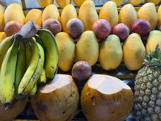fresh various tropical fruits stand in the shop window night market Asia pineapple banana passion fruit mango coconut smoothie fresh