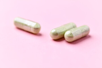 Barley grass capsules. Antioxidants. Concept for a healthy dietary supplementation. Bright background. Soft focus. Close up. Copy space.	