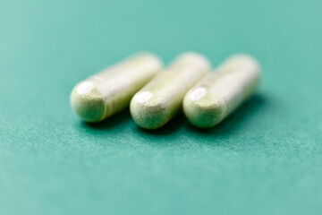 Barley grass capsules. Antioxidants. Concept for a healthy dietary supplementation. Bright background. Soft focus. Close up. Copy space.