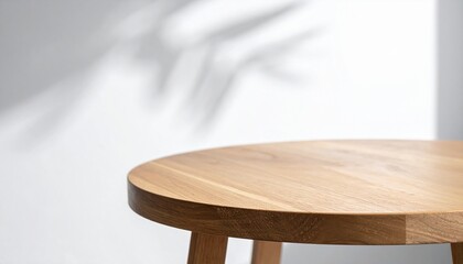 Wooden table top against white wall with leaf shadow overlay background