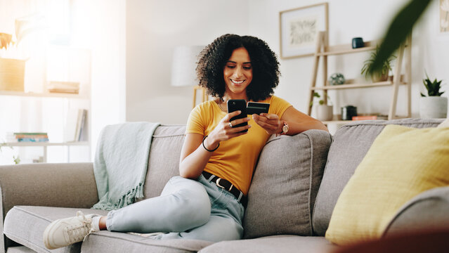 Credit card, happy and woman on sofa with phone for online shopping, web store sale and purchase. Home, relax and person on smartphone for internet payment, digital order and ecommerce in living room - Powered by Adobe