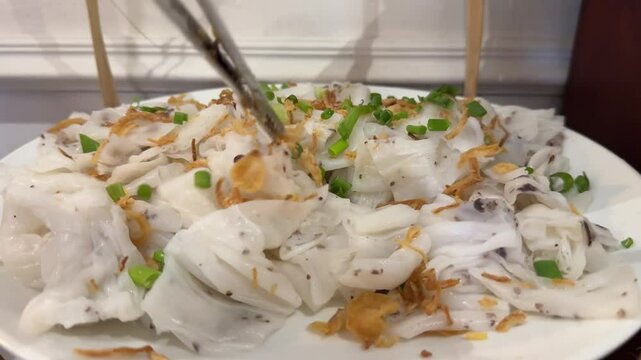 white rose dumplingsStanding on a plate on a buffet table in a hotel restaurant is Vietnamese traditional food with hoi anu garnished with green onions and carrots dried meat