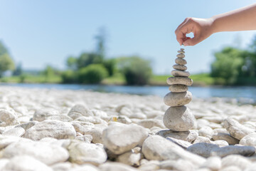 Kid boy playing with stones on the Riverside. Child play with pyramid of stones on the Riverside,