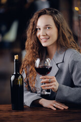 Portrait Caucasian female adult sommelier enjoying red wine in elegant setting