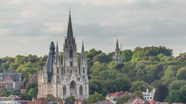 Aerial evening view of Notre Dame de Laeken church spires timelapse in Brussels, Belgium. Neo-gothic architecture surrounded by historic facades, lush green park areas and picturesque urban scenery