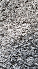 Fototapeta premium Textured stone wall with intricate patterns and a natural gray tone in close-up view