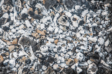 Close-up of a pile of actively smoldering coal on a dark background.