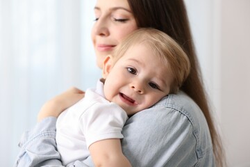 Mother with her cute little baby at home, selective focus