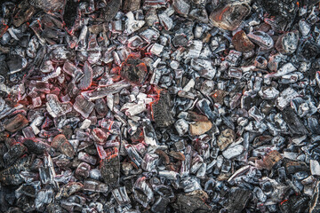 Close-up of a pile of actively smoldering coal on a dark background.