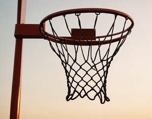 Naklejka premium Close-up of a basketball hoop against a colorful sunset sky, capturing the essence of the game.