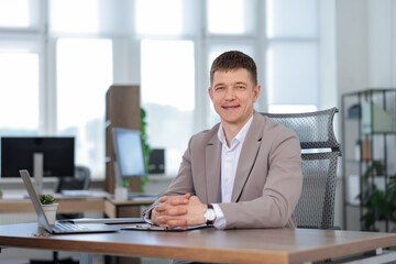 Portrait of handsome man at desk in office. Space for text