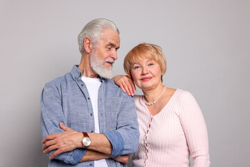 Lovely senior couple posing on grey background