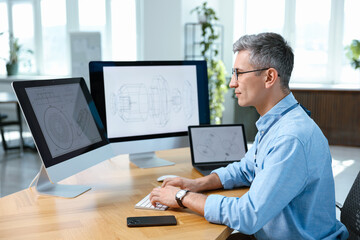 Fototapeta premium Engineer working with digital drawings at table in office