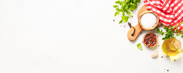 Spices, herbs and vegetables with olive oil on white kitchen table.