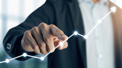 Businessman pointing at rising graph, symbolizing growth and success in quarterly targets, showcasing determination and focus