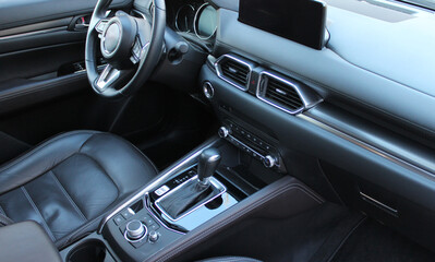 View of the driver's position in the car as seen by a car passenger. Vehicle interior with switched off touch screen monitors and instrument cluster