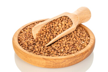 Raw buckwheat in a wooden plate isolated on a white background, macro.