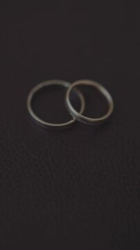 Pair of wedding rings and flashing fire on black background extreme closeup. Traditional precious accessories for newlywed couple. Symbol of fireless love