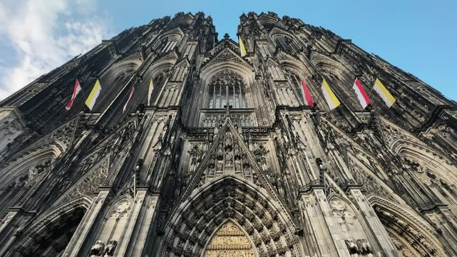 Cologne Dom cathedral seen from below with blue sky. Cologne Cathedral, or Kolner Dom, is the main landmark of Cologne and a catholic church in Germany.