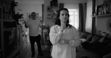 Woman contemplating deeply during heated argument, while man in background gestures in frustration, highlighting tension and unresolved issues in a couple’s relationship