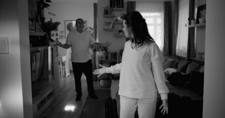 Woman holding her head in frustration during heated argument, while man in background gestures...
