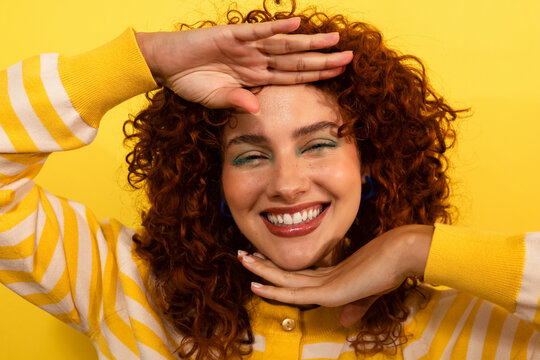 Cheerful woman smiling in vibrant yellow background