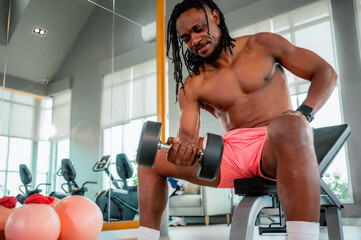 Muscular man performs various strength training exercises with dumbbells in a modern gym, showcasing power, focus, and dedication to fitness.