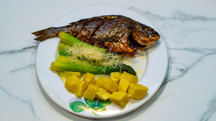 baked Dorado fish, tender green asparagus sprinkled with grated cheese, and diced potatoes with bramble.