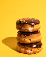 Three Boston cream donuts in a stack