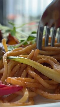 lunch pasta with tomatoes sweet pepper meat and vegetables twist with a fork delicious spaghetti close-up