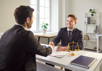 Male attorney or lawyer shaking hands with a client in an office during a meeting. Handshake symbolizes agreement, collaboration, and a successful deal in the field of law and professional services.