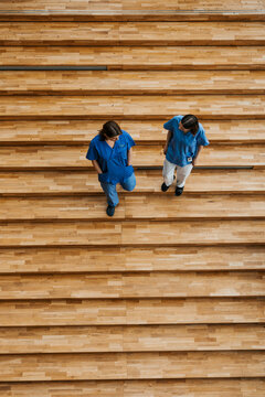 Directly above shot of female doctors talking with each other while moving down steps