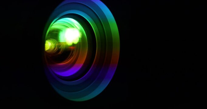 Spectral decomposition of light. Dispersion - decomposition of light into spectral colors. Projector lens in operation. Black background