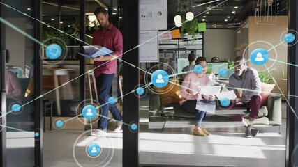 Office workers reviewing printed documents in business office, showing digital network overlay - Powered by Adobe