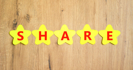 Share symbol. Concept word Share on beautiful yellow paper stars. Beautiful wooden table wooden...