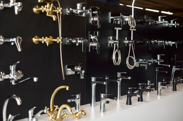 Interior of plumbing showcase with faucet for bathroom with modern water taps in construction market or building shop. Hardware store or shopping mall of bath equipment for repair.