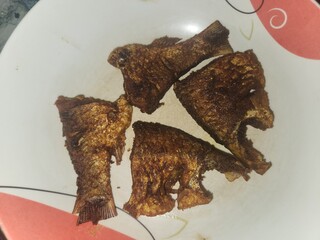 Tasty fried fish pieces on frying pan.