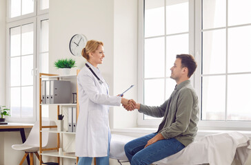 Obraz premium Young doctor, female nurse handshake, provide medical care service, meeting in clinic male patient to help during medical visit, lady carer greeting man in hospital, med clinic for checkup exam