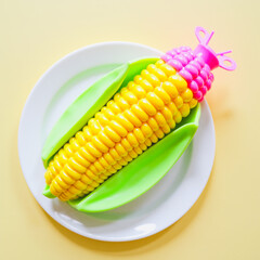Plastic Corn on White Plate — Conceptual Image of Artificial Food and Neon Aesthetics	