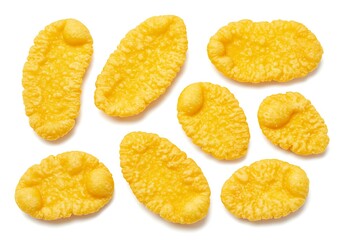 A top view of several golden yellow senbei rice crackers scattered on a white surface evenly spaced out