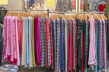 Colorful clothes hanging on racks and sold outside on a market