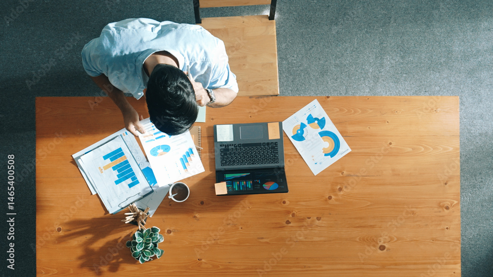 Poster top aerial view of manager working on laptop while looking at data analysis. leader compare financia