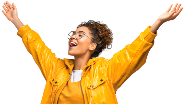 Joyful young woman in yellow raincoat celebrates with arms outstretched against a white background