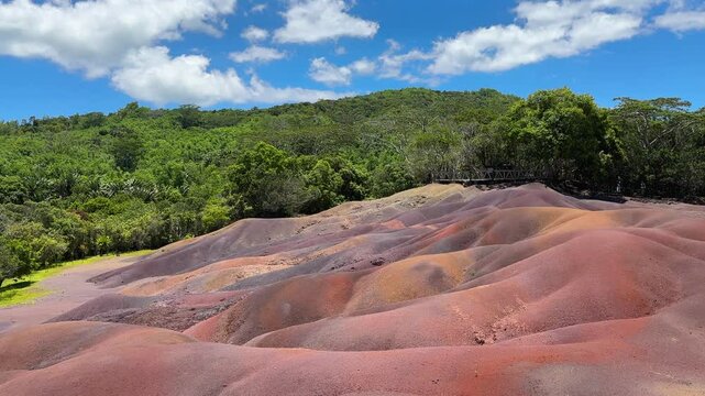 Famous Mauritian Landmark: The Seven Coloured Earths Geopark with Tropical Greenery.Unique Seven Coloured Earths of Chamarel, Mauritius: Vibrant Geological Wonder with Lush Forest Backdrop