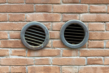 Two Round Vent Grilles in Brick Wall